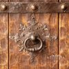 Puerta estilo cava en madera soleada y cardada con herraje cincelado
